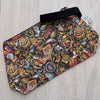 Colorful patterned pouch with a black strap on a light wooden surface