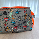 Pouch with tattoo-themed design on a light surface