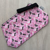 Pink pouch with black text pattern on a gray surface