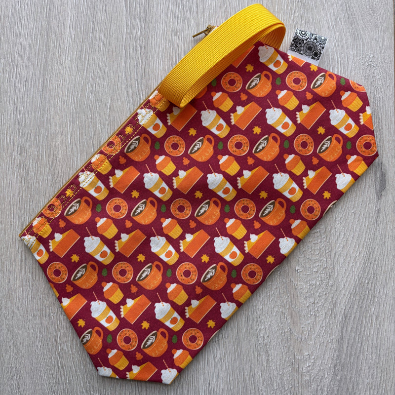 Fabric pouch with Halloween-themed pattern on a wooden surface