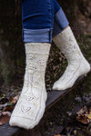 feet wearing grey lace knit socks walking on a beam