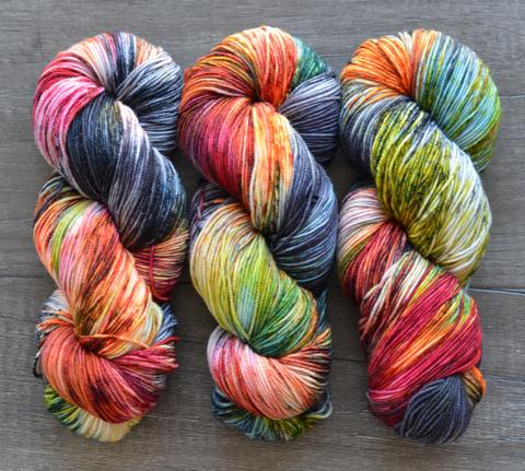 pink, grey,orange, green, red, and cream variegated skeins of yarn