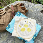 embroidery kit with a duffel bag on a rock