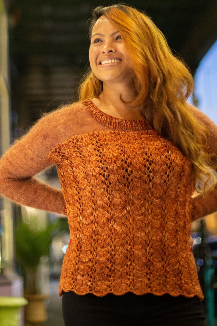 a woman wearing a burnt orange knit lace sweater