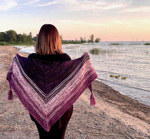 woman walking on a beach wearing a triangle shawl