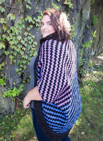 a brunette woman standing wearing a long chevron-striped knit bolero cardigan