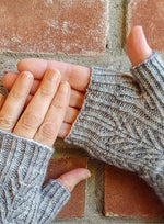hands wearing patterned knit fingerless gloves
