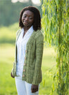a black woman standing wearing a green knit cardigan
