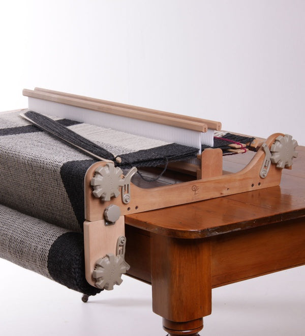 rigid heddle loom with a freedom roller attached sitting on a table.