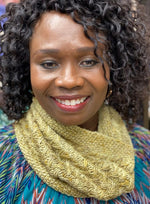 a black woman smiling wearing a yellow knit cowl